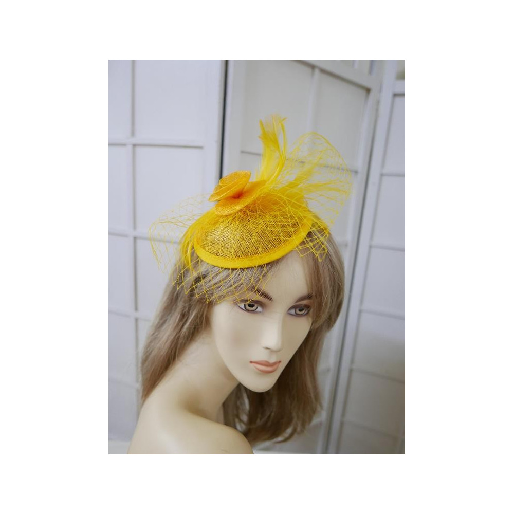 Żólty fascynator z sinamay z woalką i piórami na przepasce