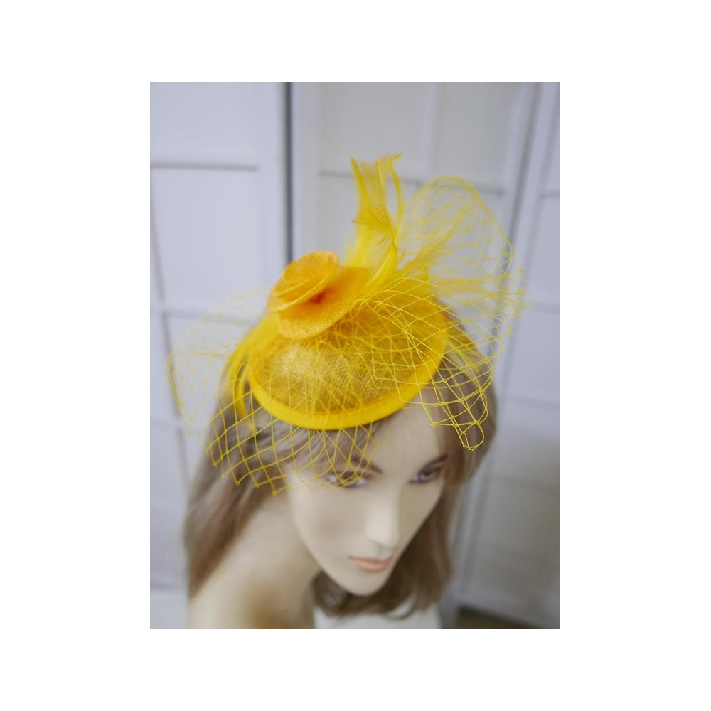 Żólty fascynator z sinamay z woalką i piórami na przepasce