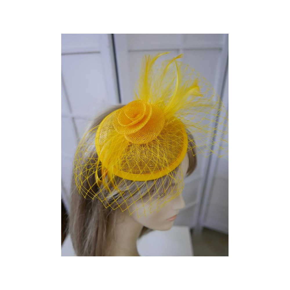 Żólty fascynator z sinamay z woalką i piórami na przepasce
