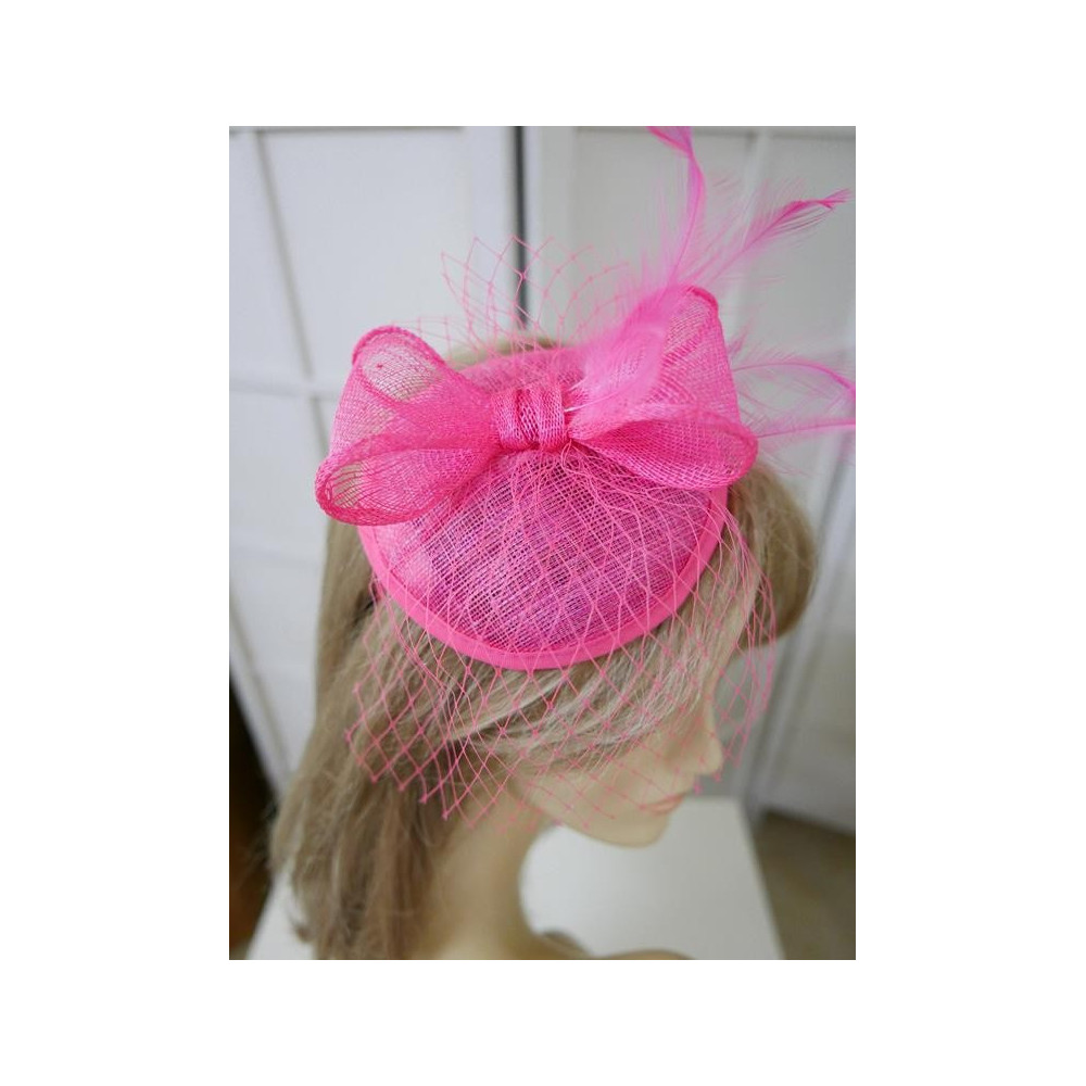 Różowy fascynator z sinamay z woalką i piórami na przepasce