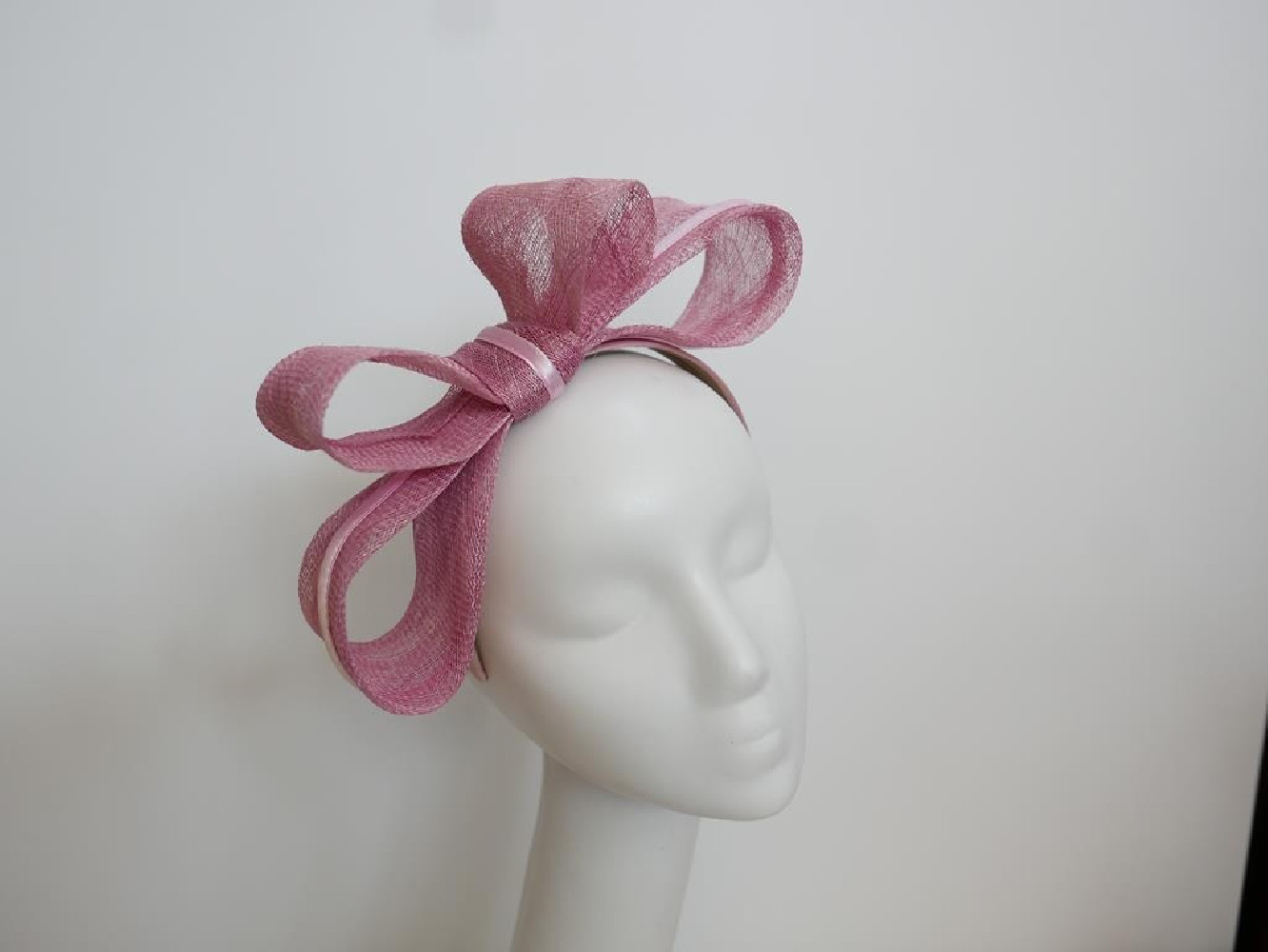 Różowy fascynator z sinamay na przepasce