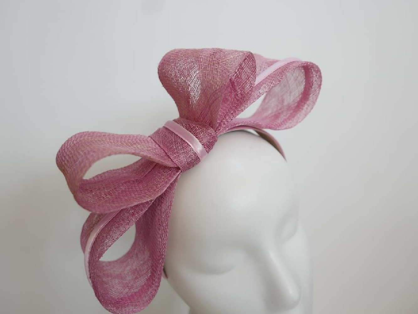 Różowy fascynator z sinamay na przepasce