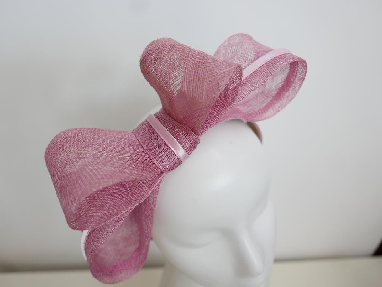 Różowy fascynator z sinamay na przepasce