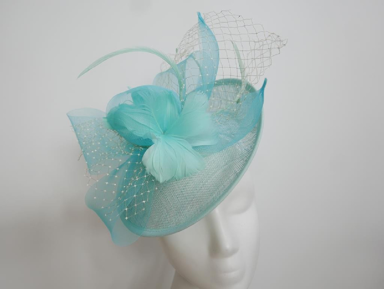 Turkusowy kapelusz koktajlowy z piórami na przepasce