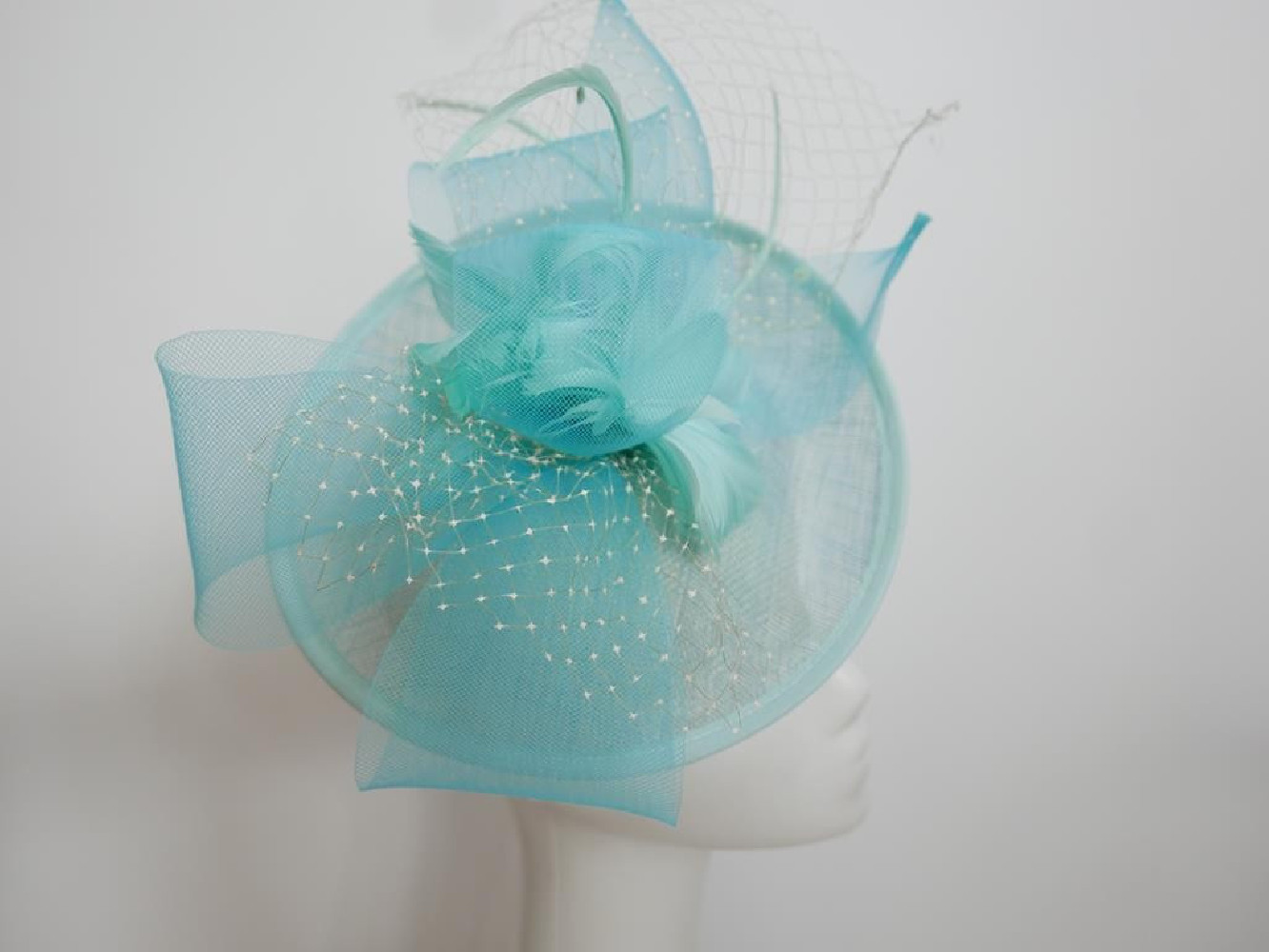 Turkusowy kapelusz koktajlowy z piórami na przepasce