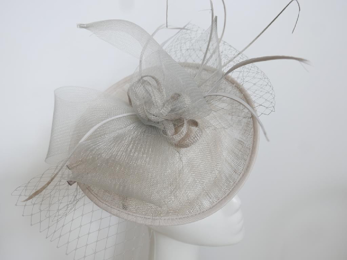 Szary kapelusz koktajlowy z piórami na przepasce