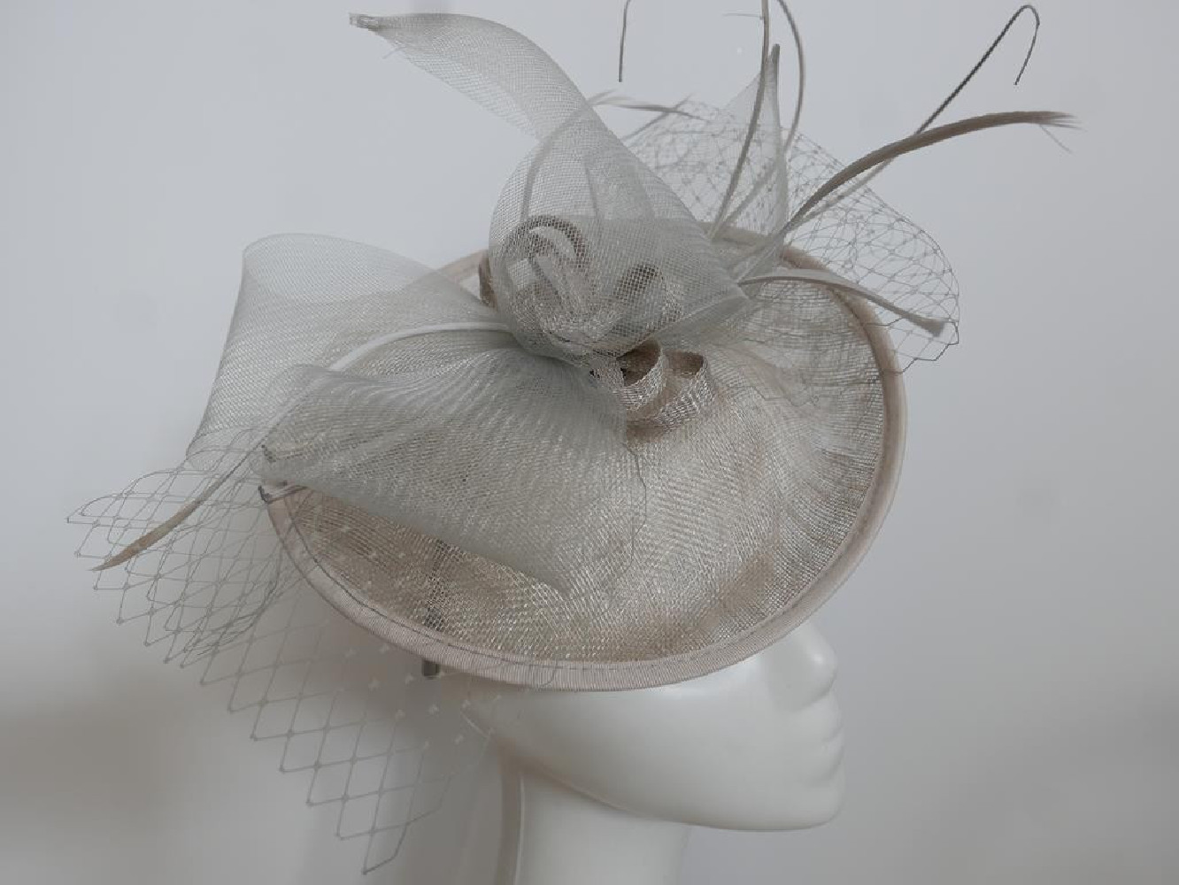 Szary kapelusz koktajlowy z piórami na przepasce