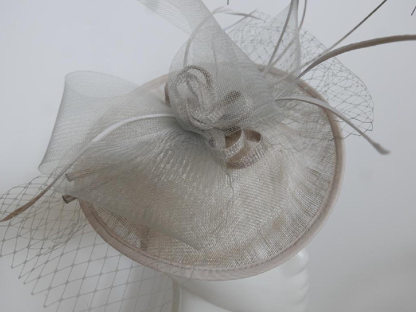 Szary kapelusz koktajlowy z piórami na przepasce