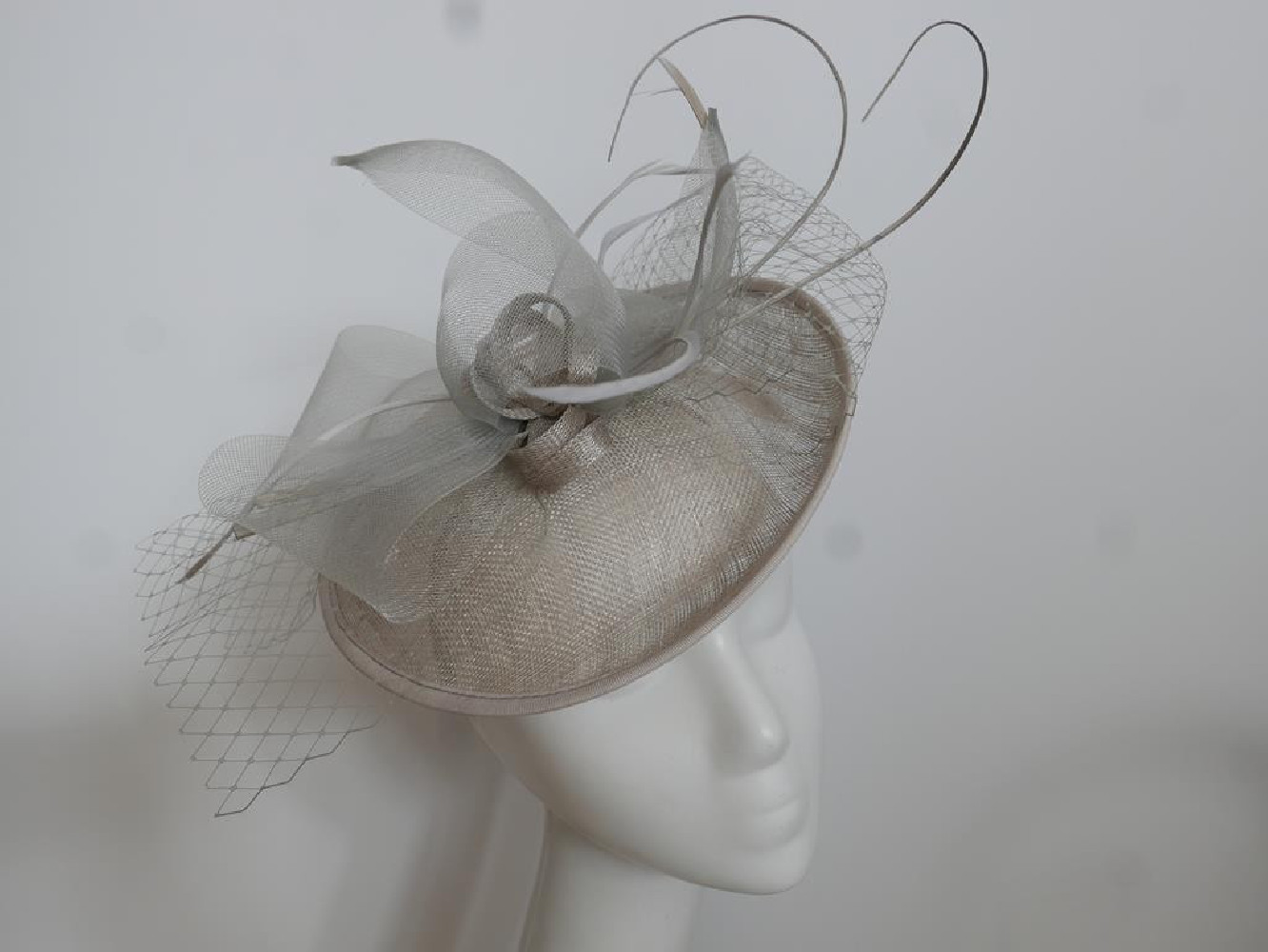 Szary kapelusz koktajlowy z piórami na przepasce