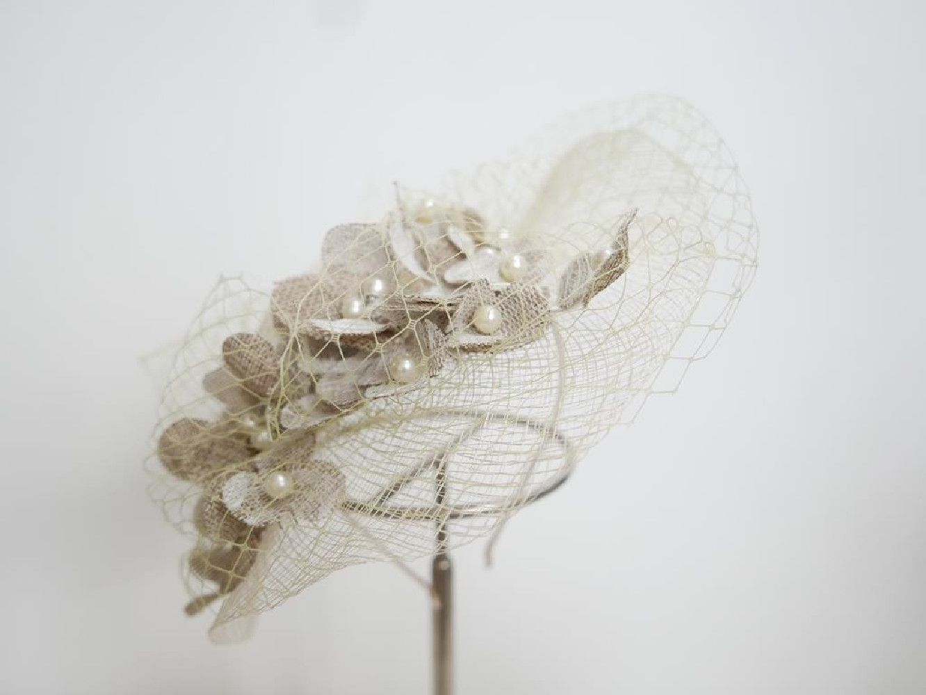 Kremowo beżowy kapelusik koktajlowy z sizalu z woalką na przepasce
