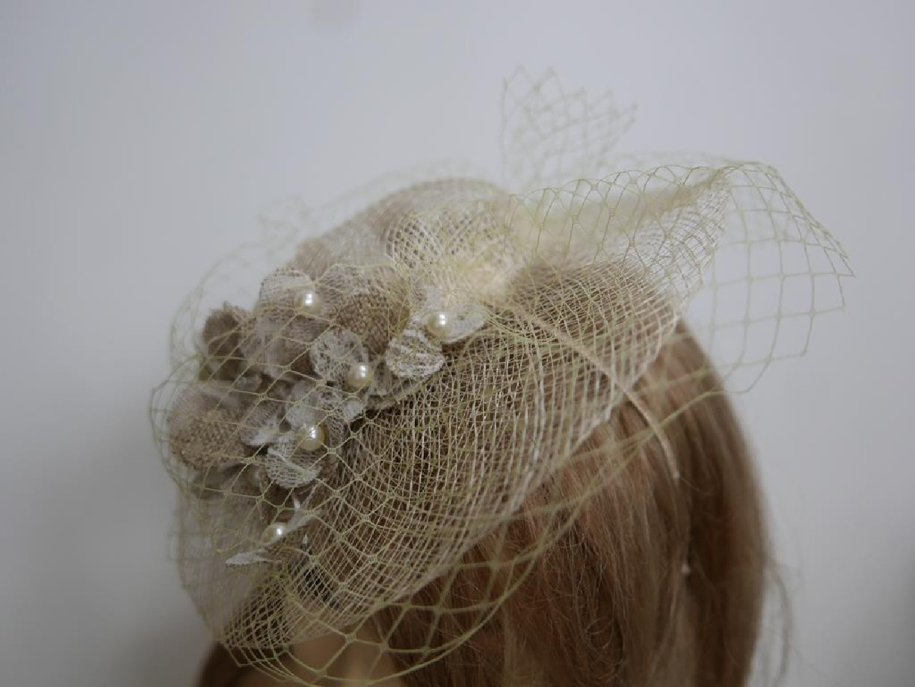 Kremowo beżowy kapelusik koktajlowy z sizalu z woalką na przepasce