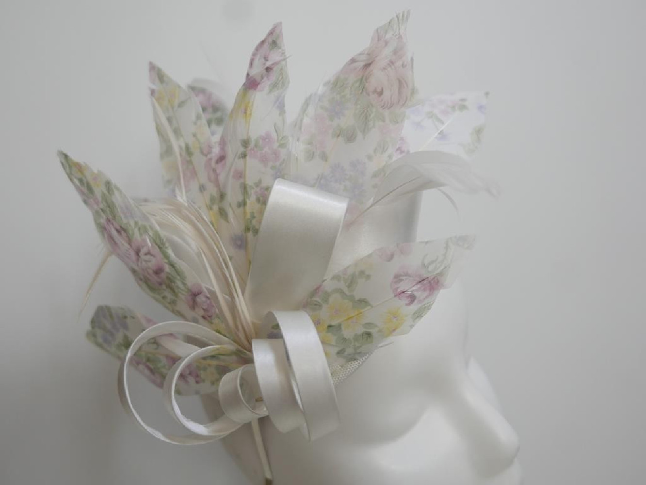 Pastelowy satynowy fascynator z piórami na przepasce