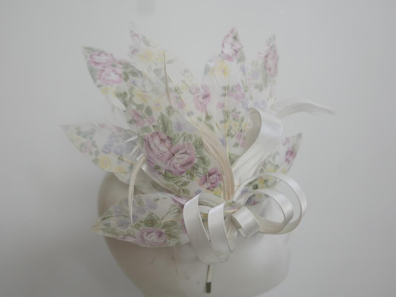 Pastelowy satynowy fascynator z piórami na przepasce