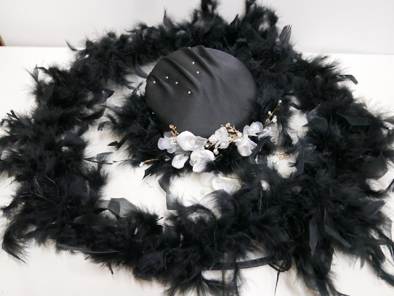Biało czarny kapelusz z tkaniny z piórami