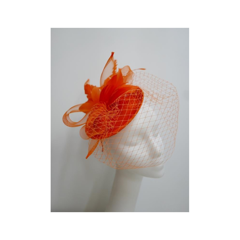 Pomarańczowy fascynator z sinamay z woalką i piórami na przepasce
