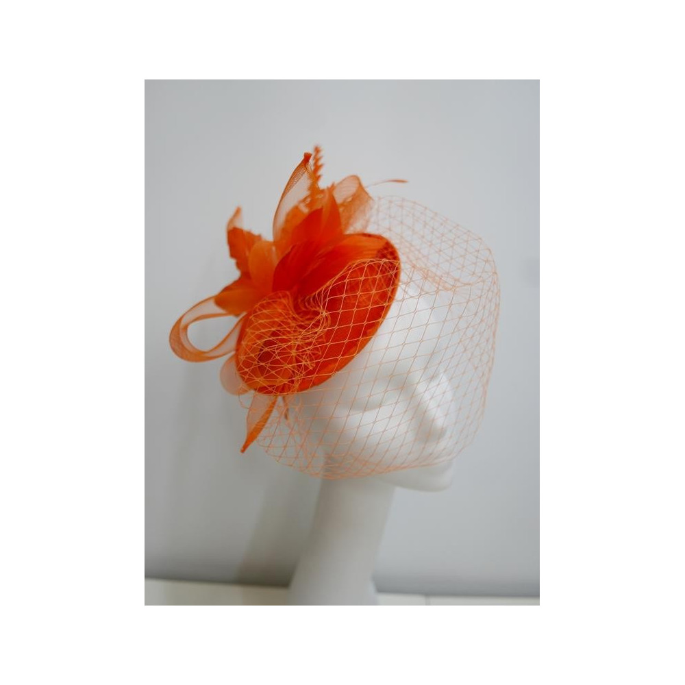 Pomarańczowy fascynator z sinamay z woalką i piórami na przepasce