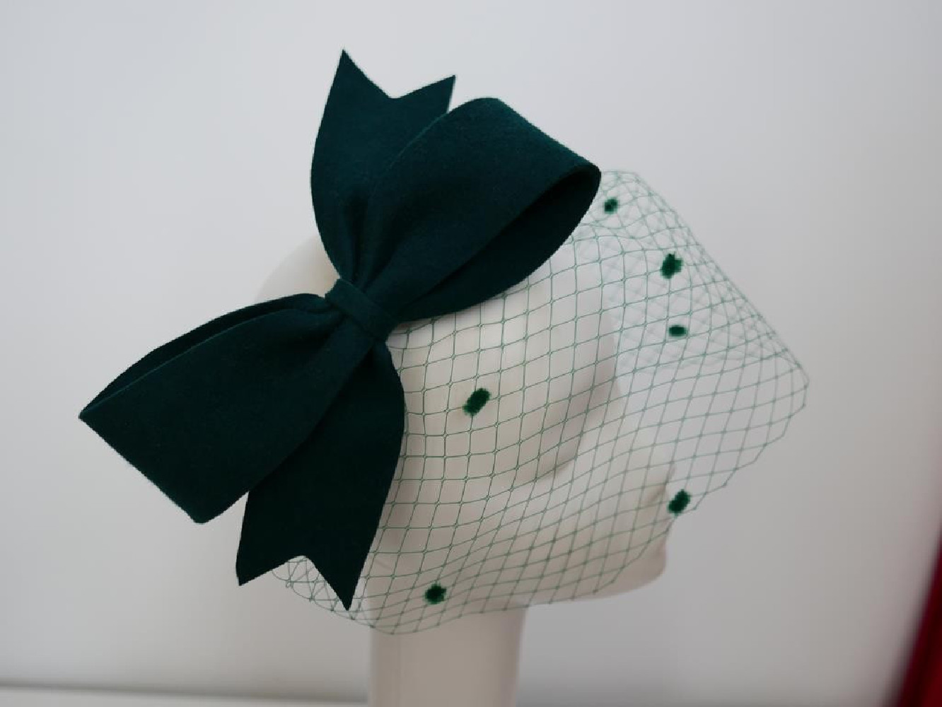 Ciemno zielony fascynator filcowy z woalką na przepasce