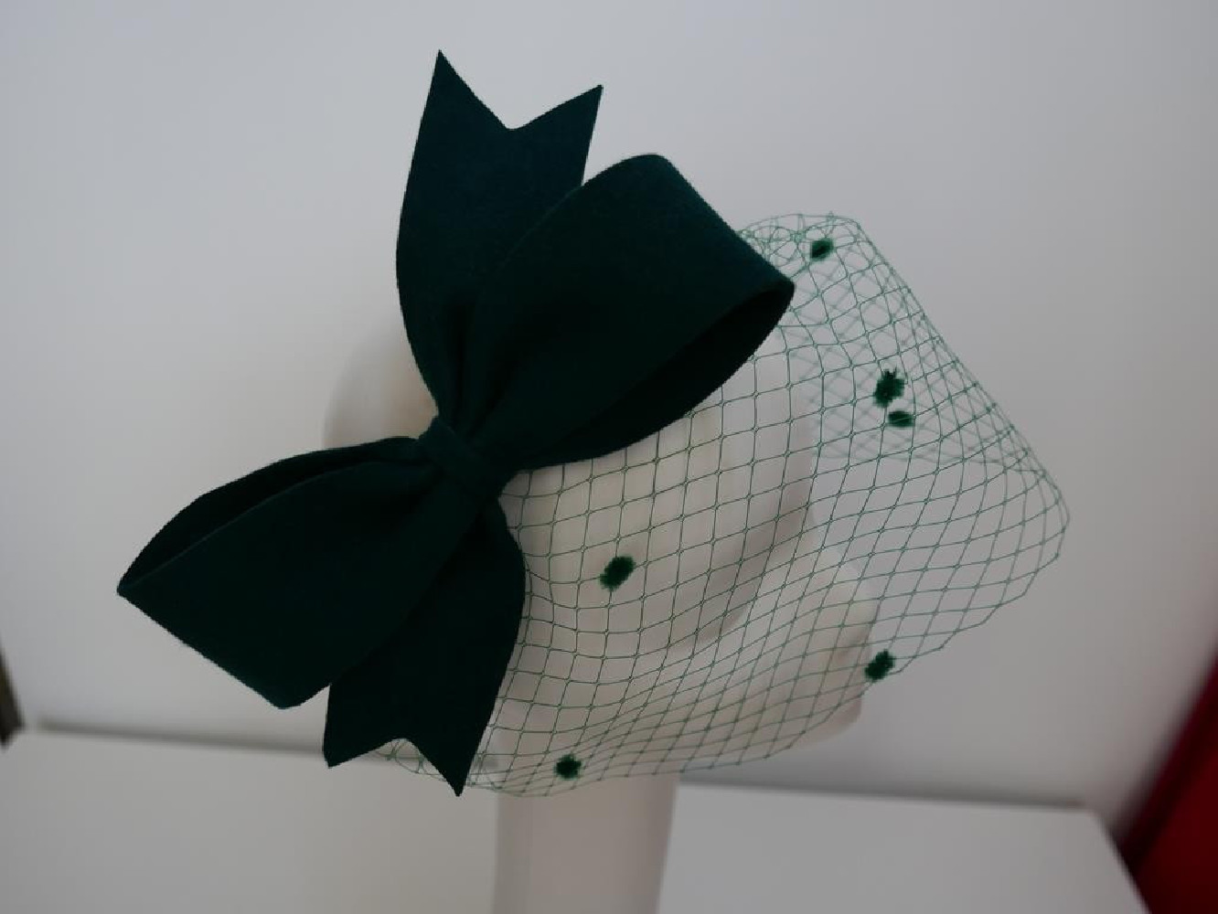 Ciemno zielony fascynator filcowy z woalką na przepasce
