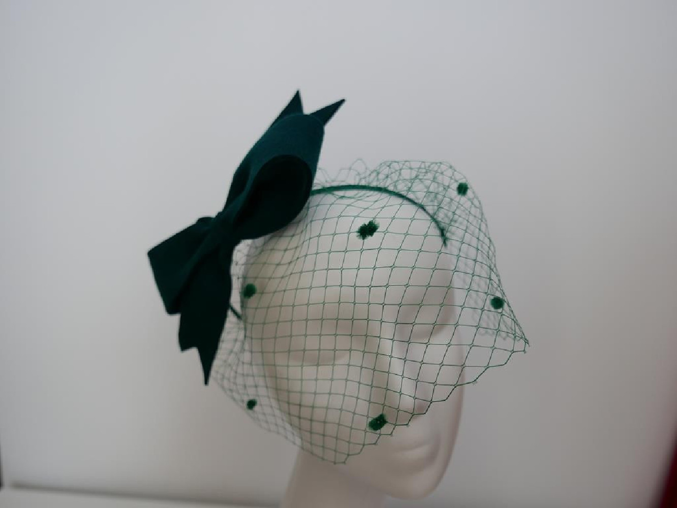 Ciemno zielony fascynator filcowy z woalką na przepasce