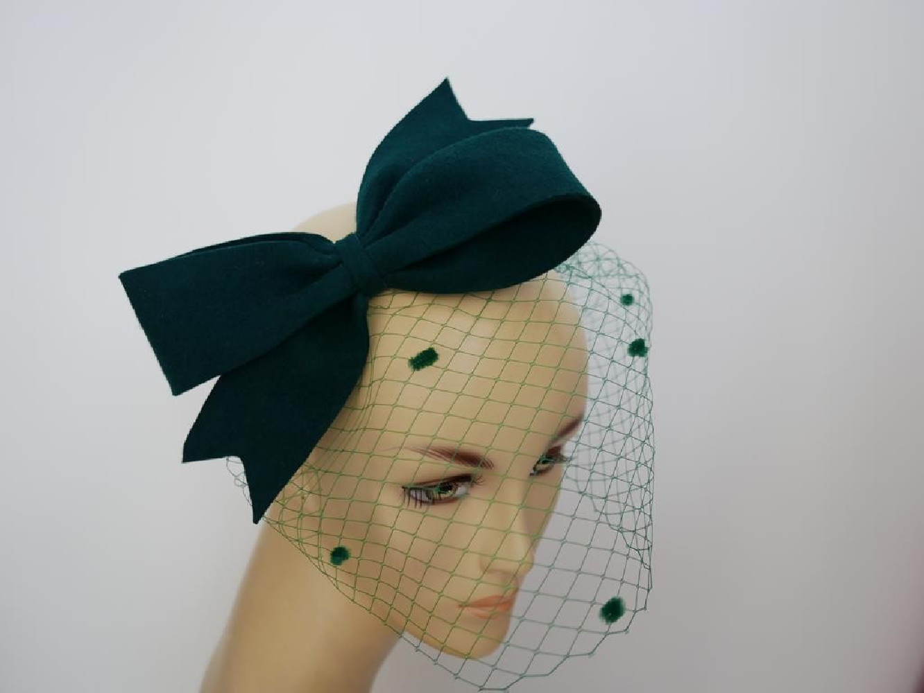 Ciemno zielony fascynator filcowy z woalką na przepasce