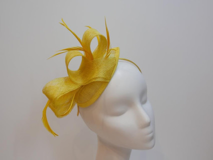 Żółty fascynator z sinamay z piórami na przepasce