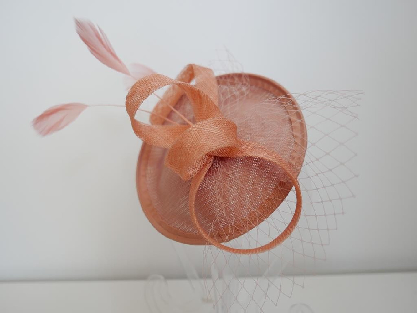 Indyjski róż fascynator z piórami i woalką na przepasce