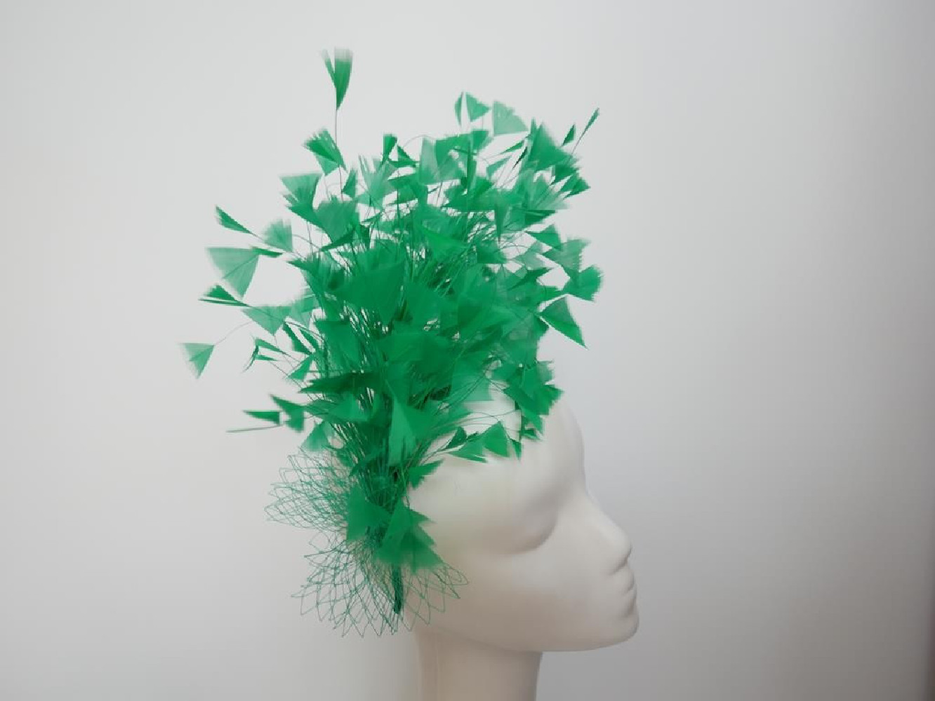 Soczyście zielony fascynator z piór z woalką