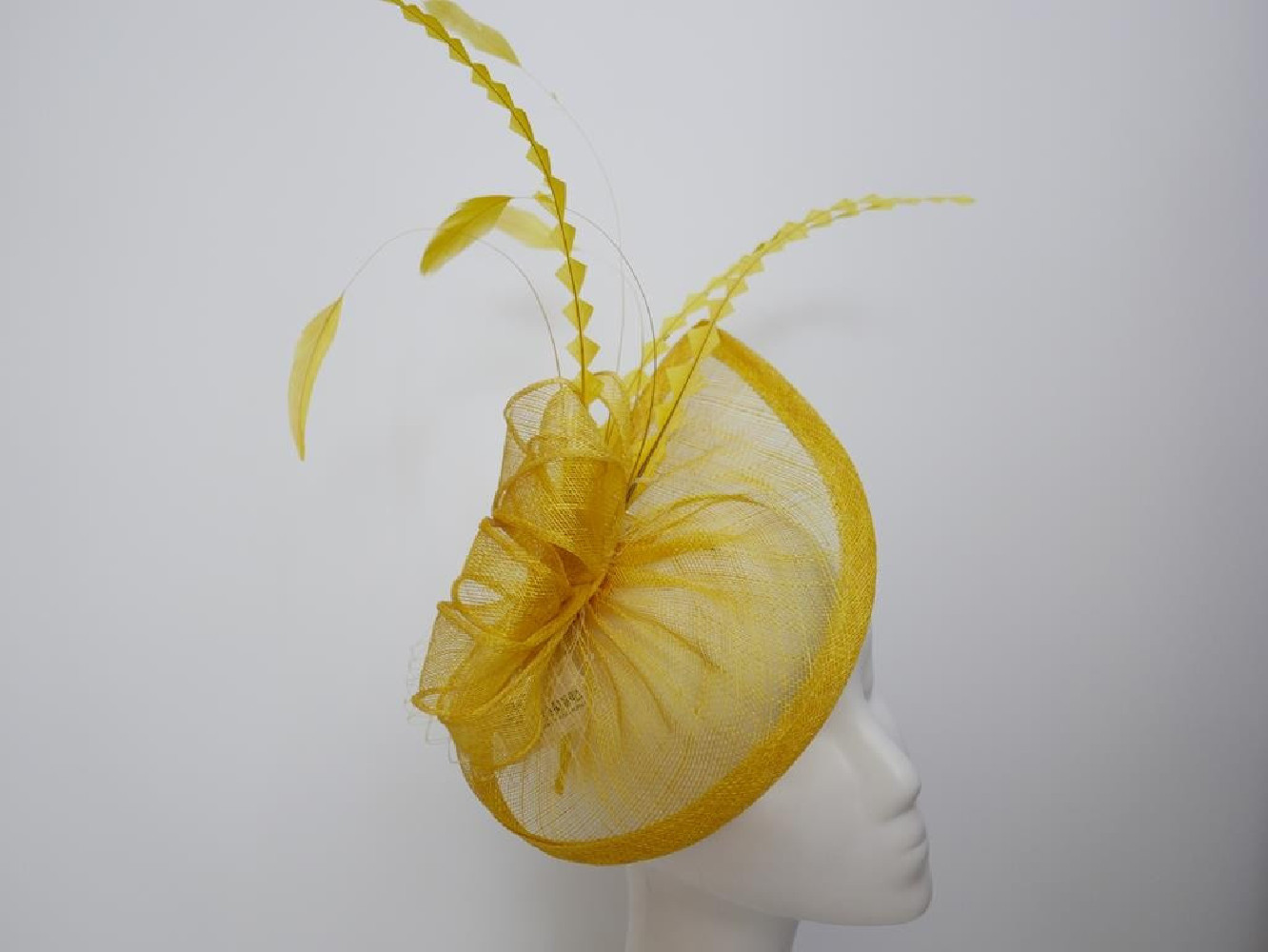 Zółty fascynator z sinamay z piórami na przepasce