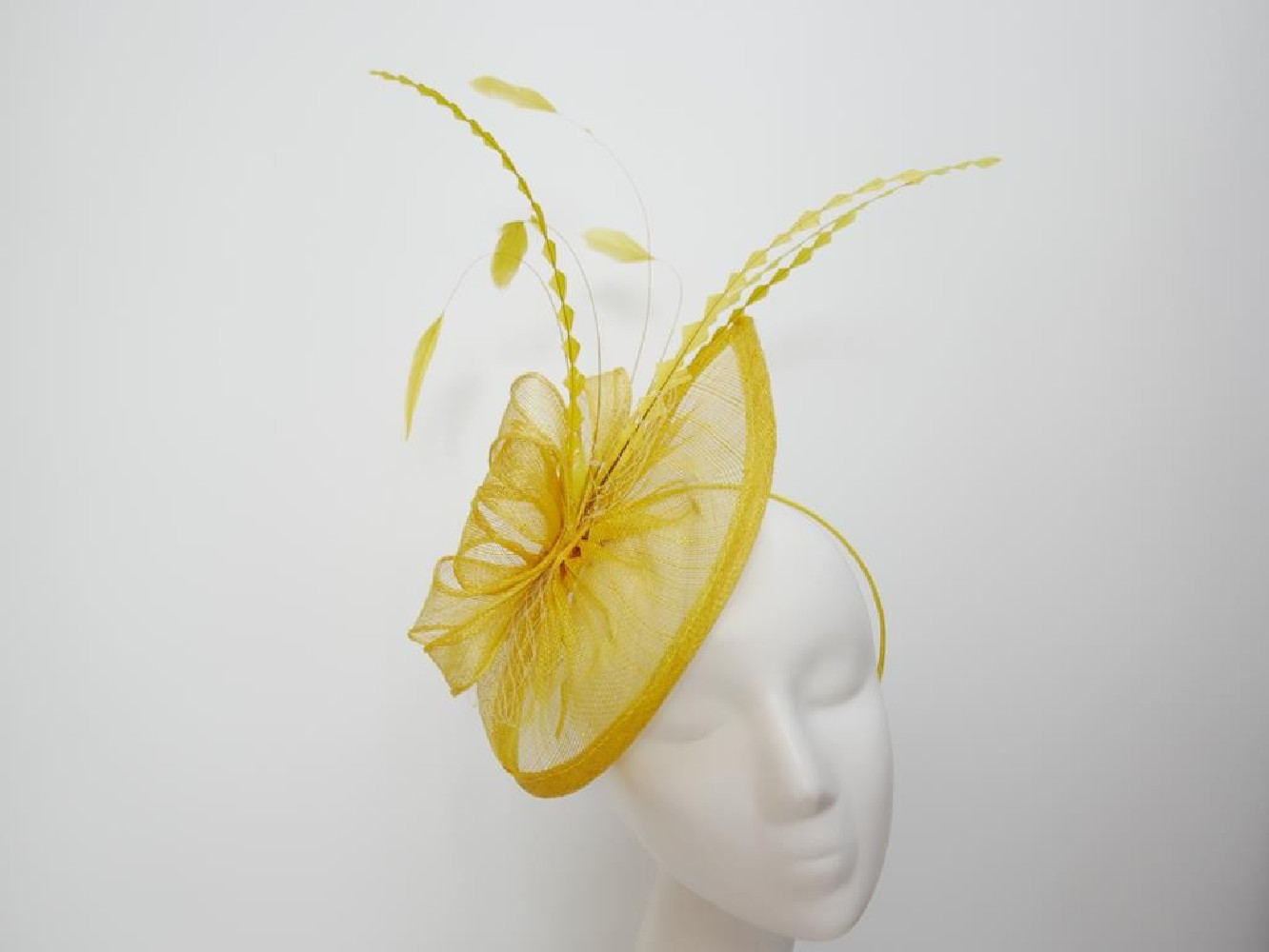 Zółty fascynator z sinamay z piórami na przepasce