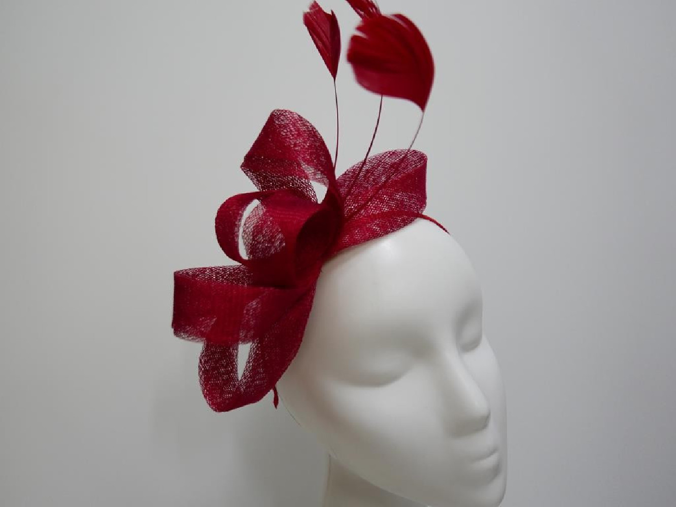 Czerwony fascynator z sinamay z piórami na przepasce