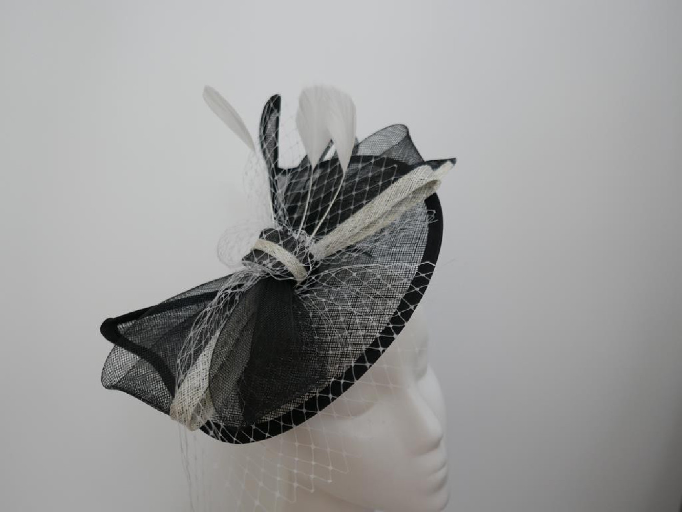 Czarno śmietankowy fascynator z sinamay z piórami na przepasce