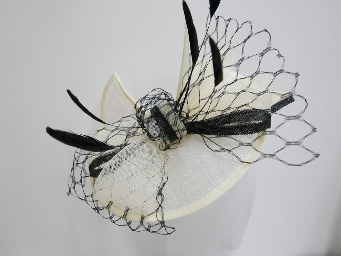 Śmietankowo czarny fascynator z sinamay z piórami na przepasce