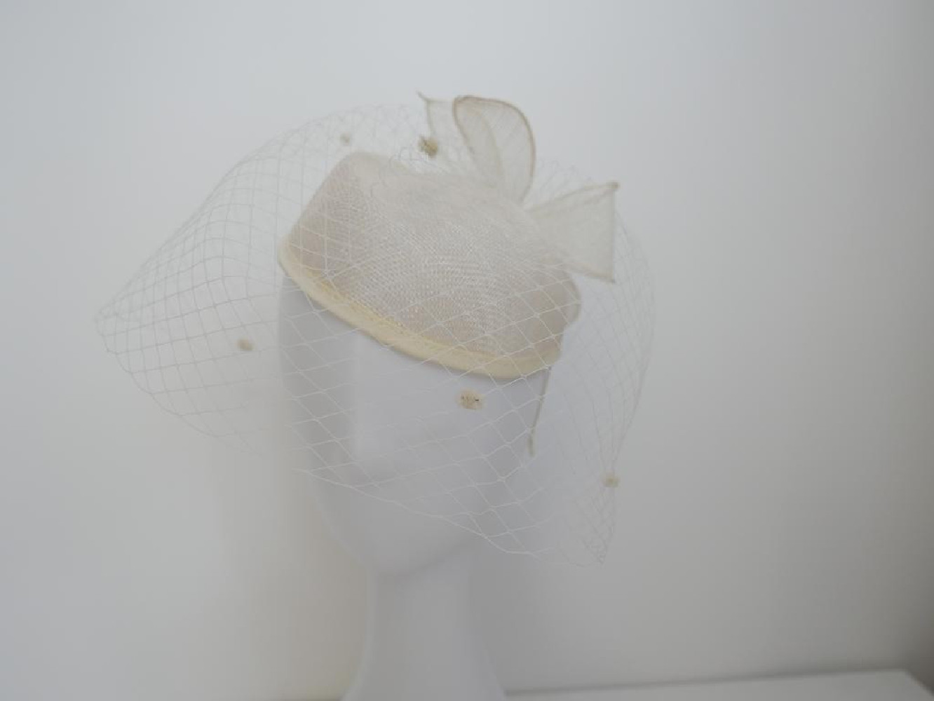 Śmietankowy toczek  z sinamay z woalką