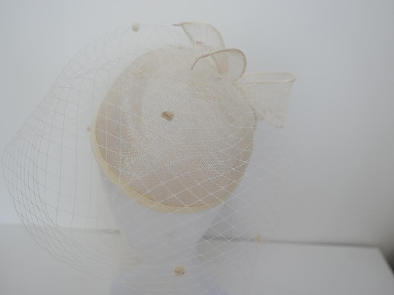 Śmietankowy toczek  z sinamay z woalką