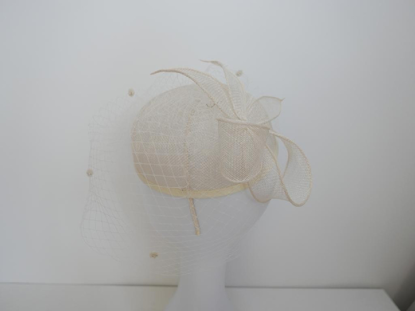 Śmietankowy toczek  z sinamay z woalką