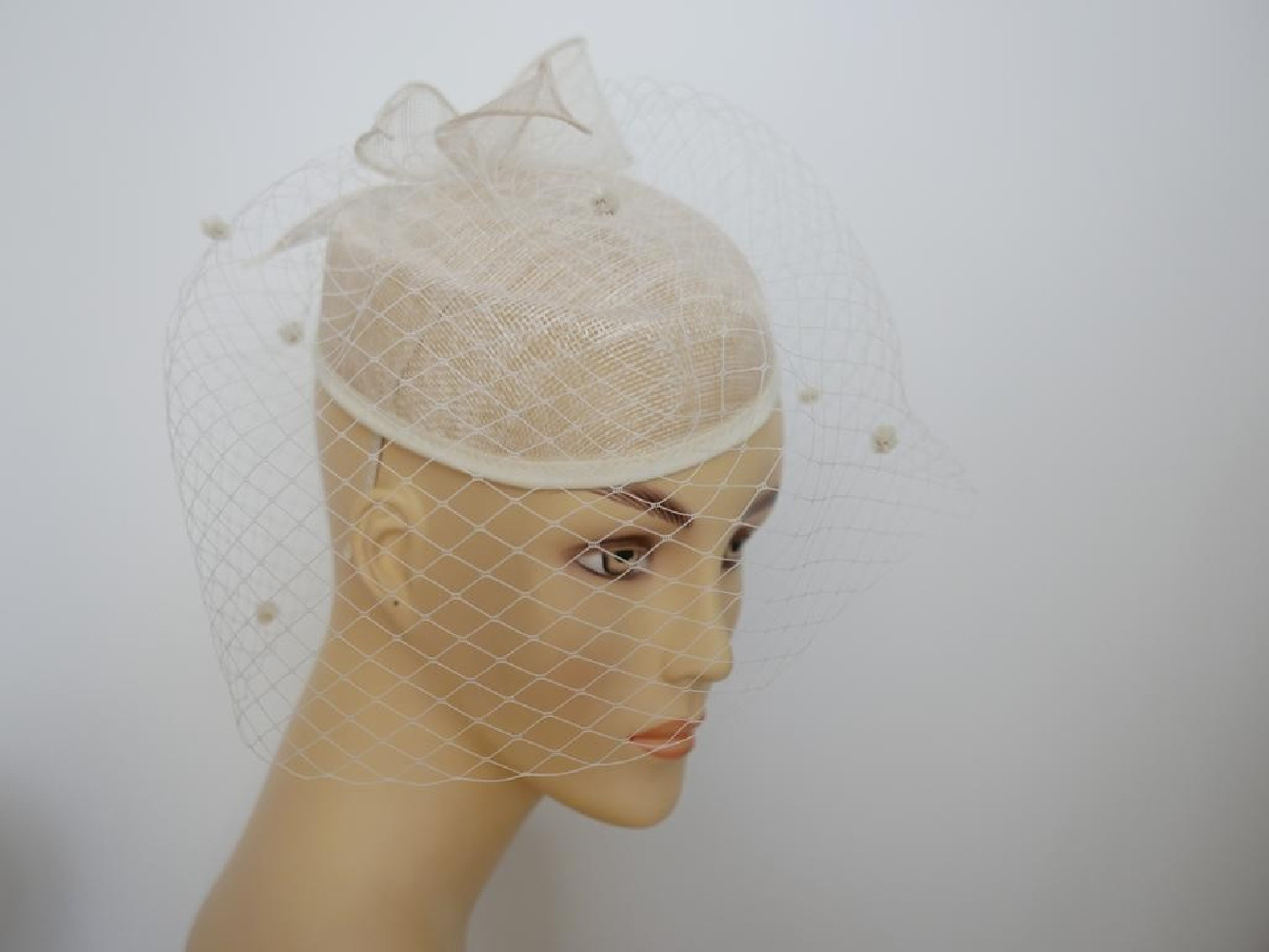 Śmietankowy toczek  z sinamay z woalką