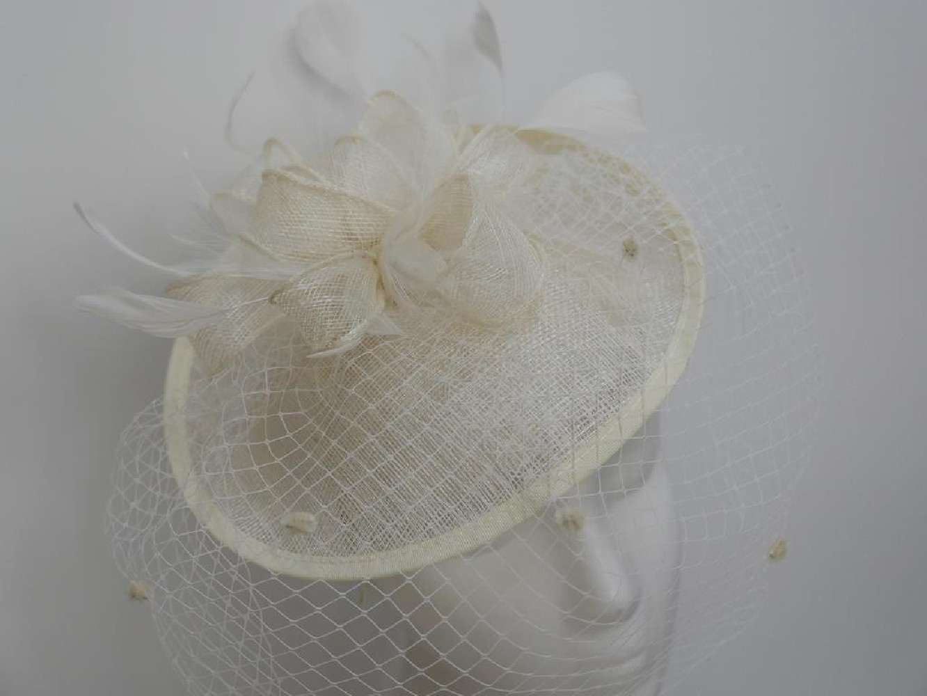 Smietankowy kapelusik koktajlowy z sinamay na przepasce