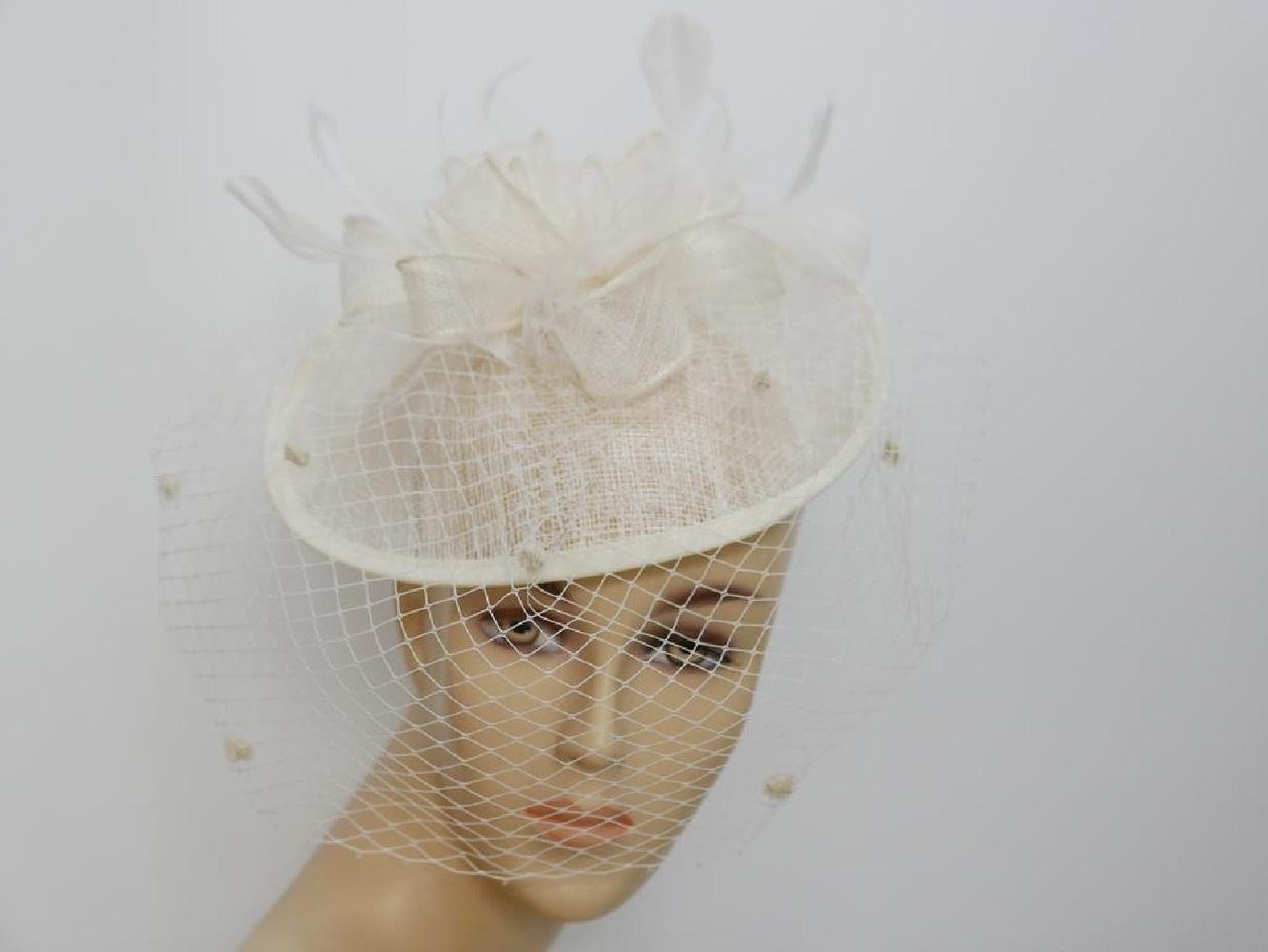 Smietankowy kapelusik koktajlowy z sinamay na przepasce