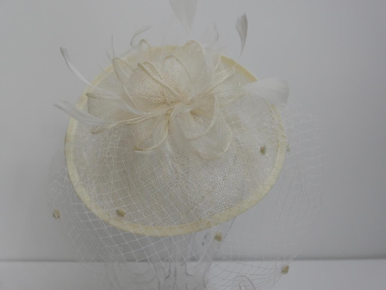 Smietankowy kapelusik koktajlowy z sinamay na przepasce