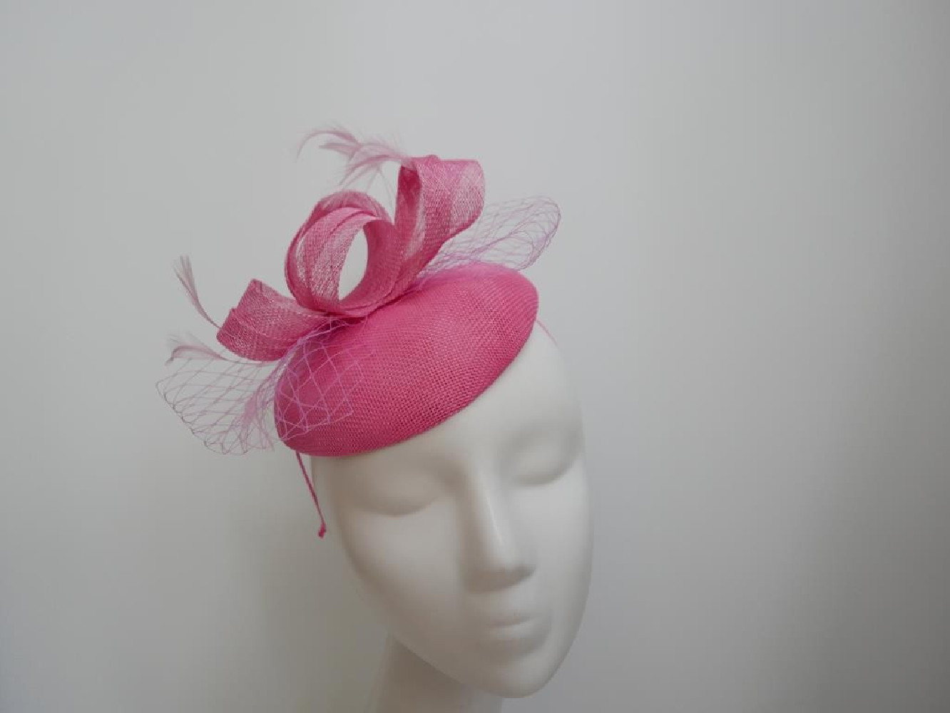 Różowy fascynator z woalką na przepasce