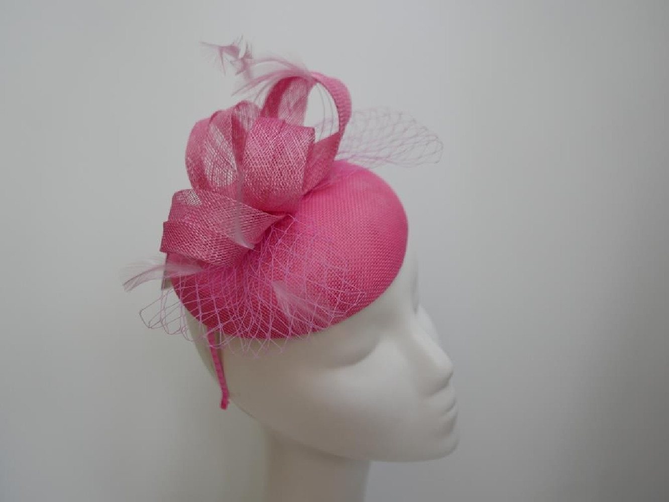 Różowy fascynator z woalką na przepasce