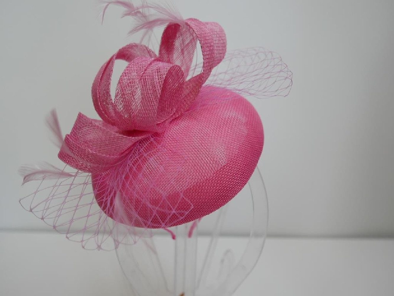Różowy fascynator z woalką na przepasce
