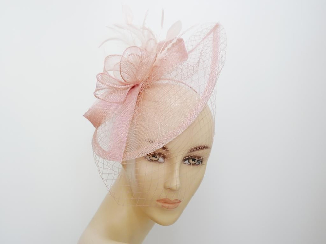 Różowy fascynator z sinamay z woalką na przepasce