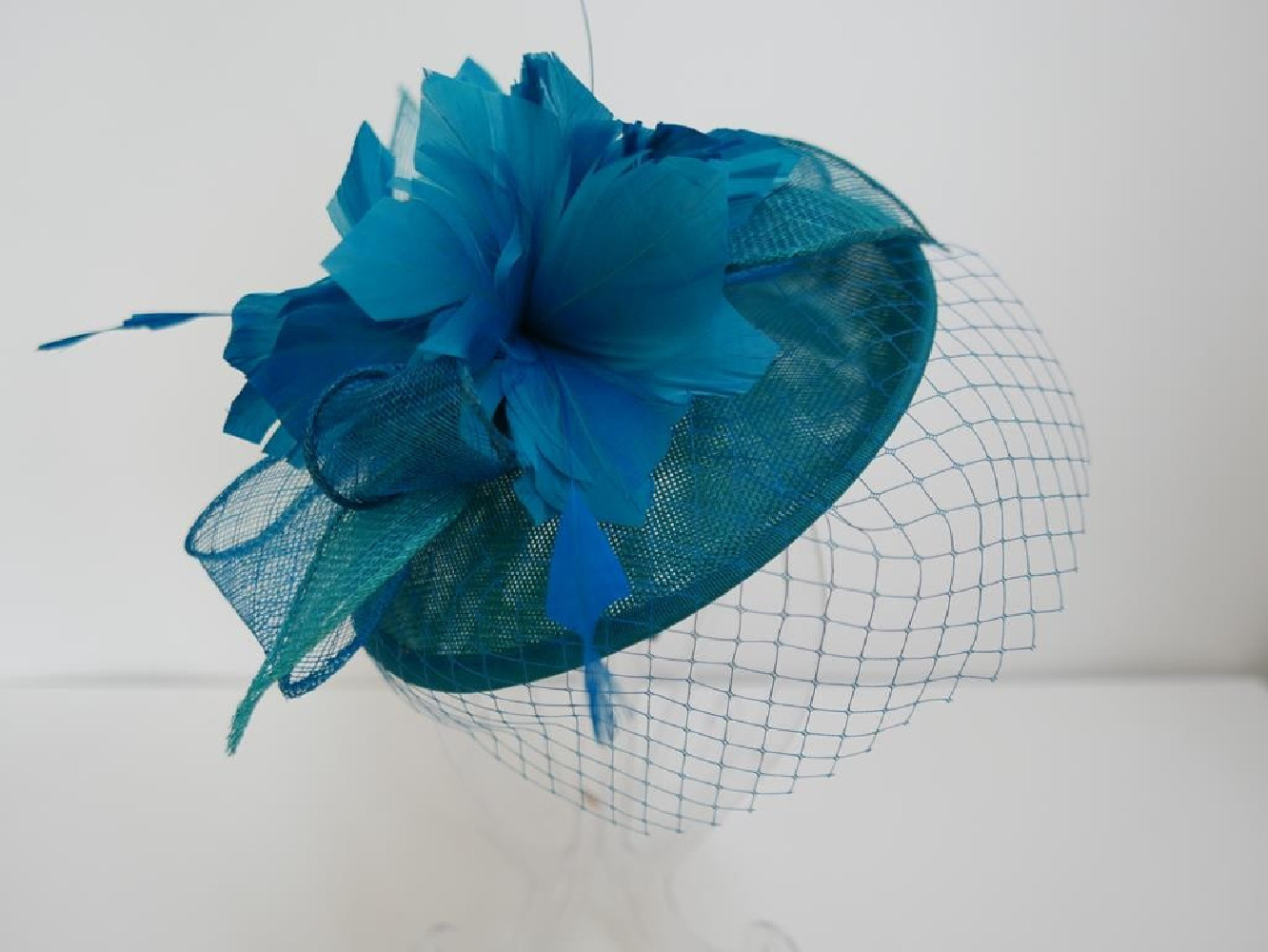 Morski kapelusik koktailowy z lnu z piórami na przepasce