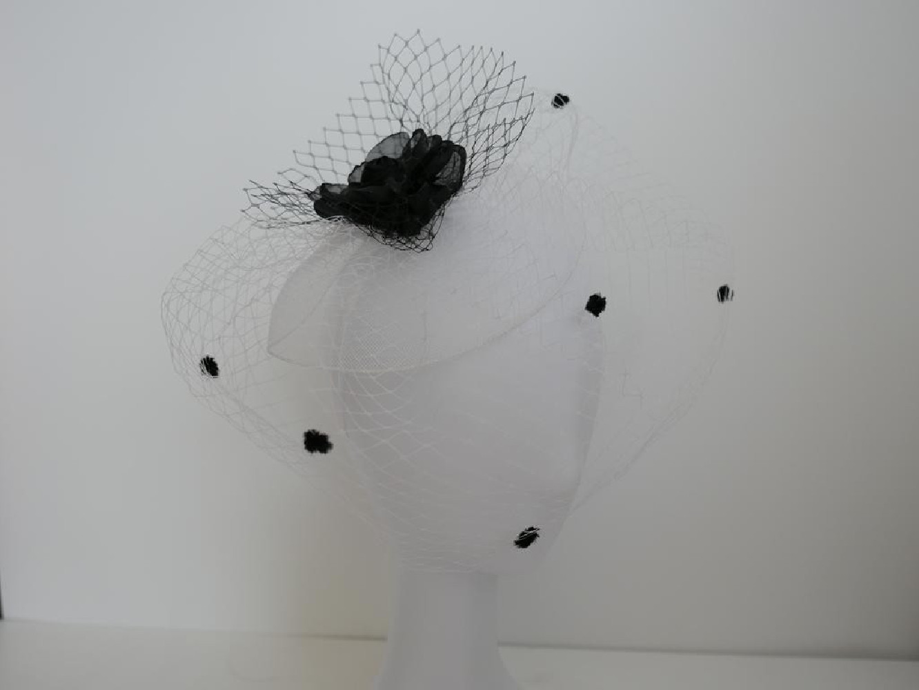 Biało czarny fascynator z woalką na przepasce