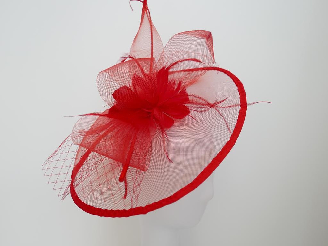 Czerwony fascynator z crin i piórami na przepasce
