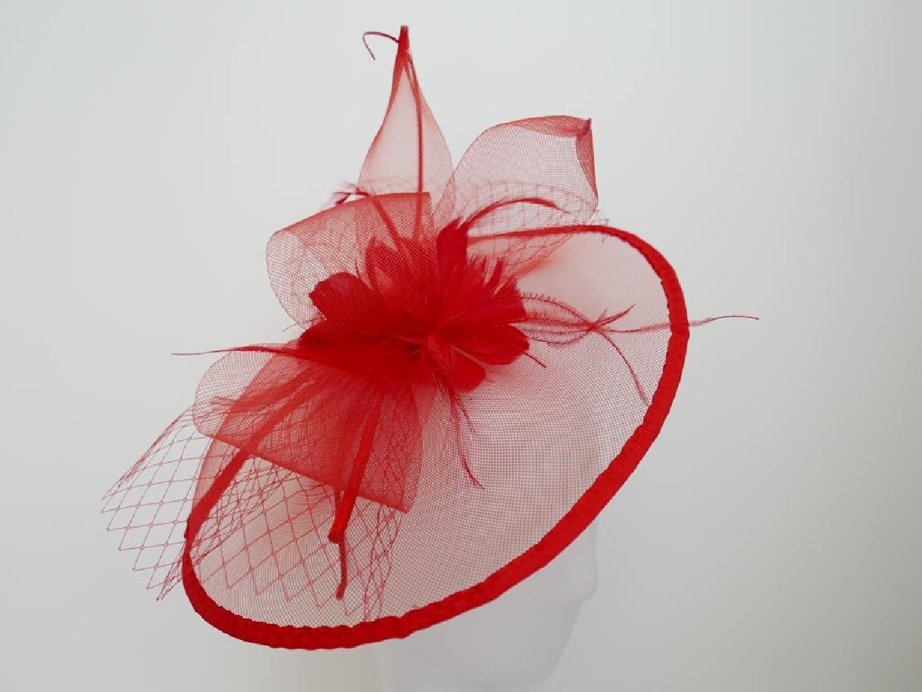 Czerwony fascynator z crin i piórami na przepasce