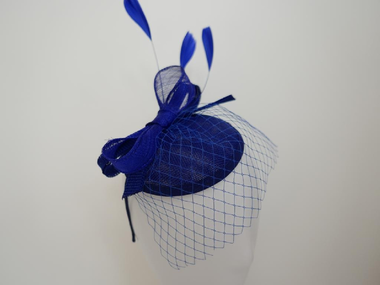 Szafirowy fascynator z woalką i piórami na przepasce