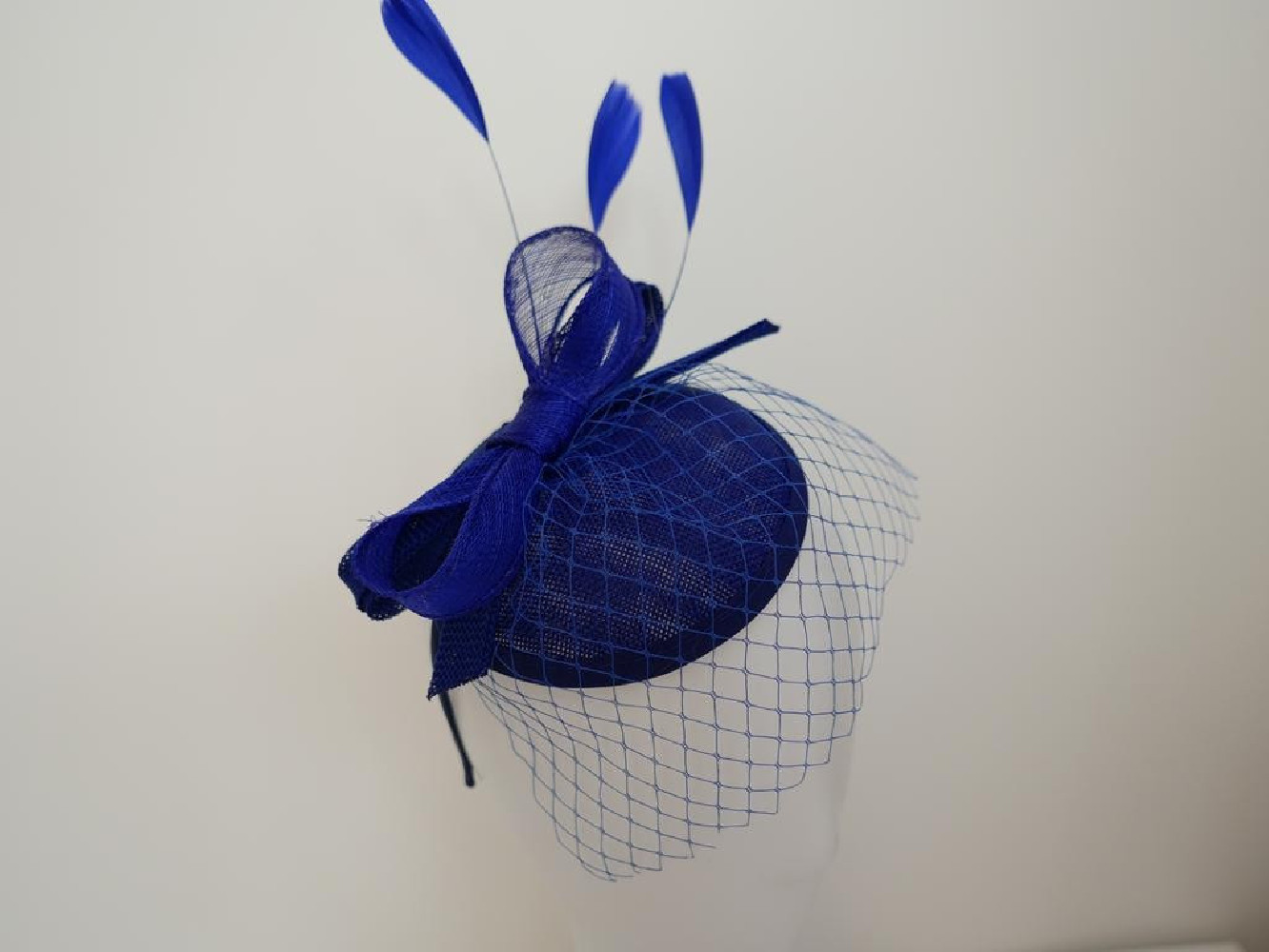 Szafirowy fascynator z woalką i piórami na przepasce