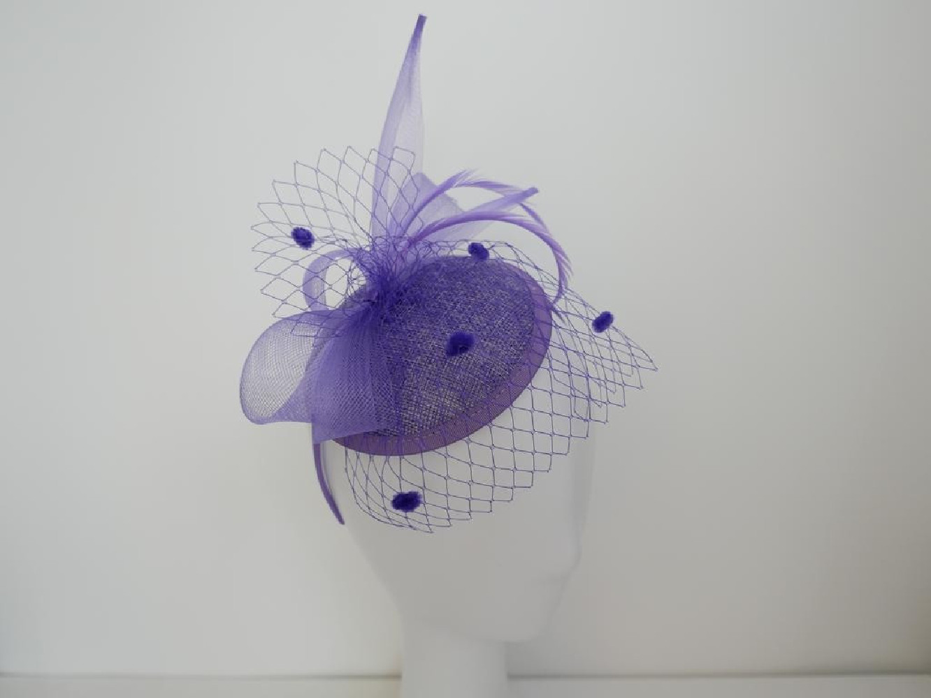 Liliowy fascynator z woalką i piórami na przepasce